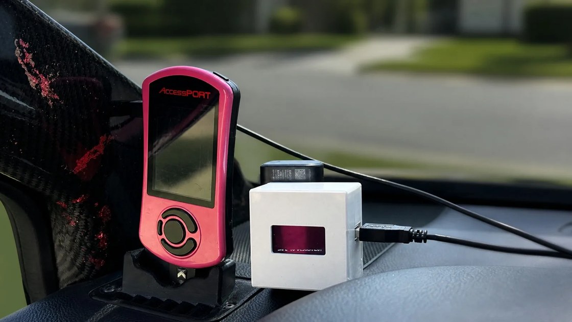 The RevLink Sidecar in a printed case on a car dashboard, cabled to a COBB AccessPort